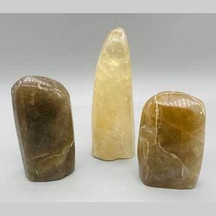 Three polished stones of different shapes and sizes on a gray background