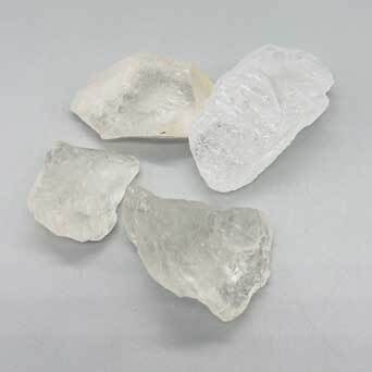 Three pieces of raw crystal on a gray background