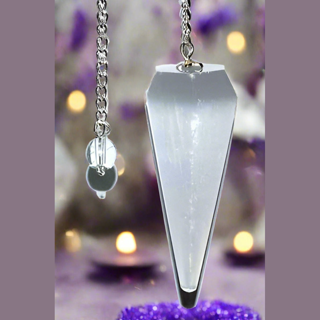 Crystal pendulum with chain on a white background