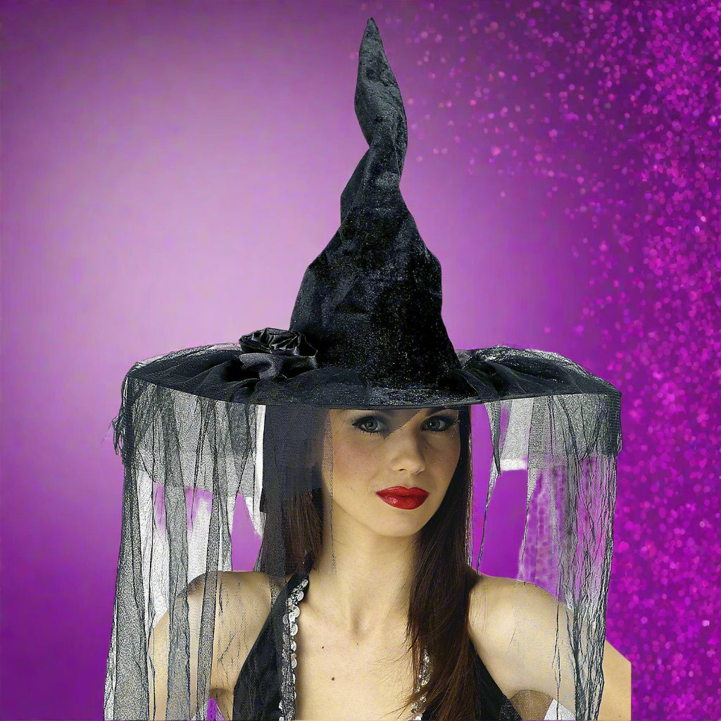 Black witch hat with veil worn by a model on a white background